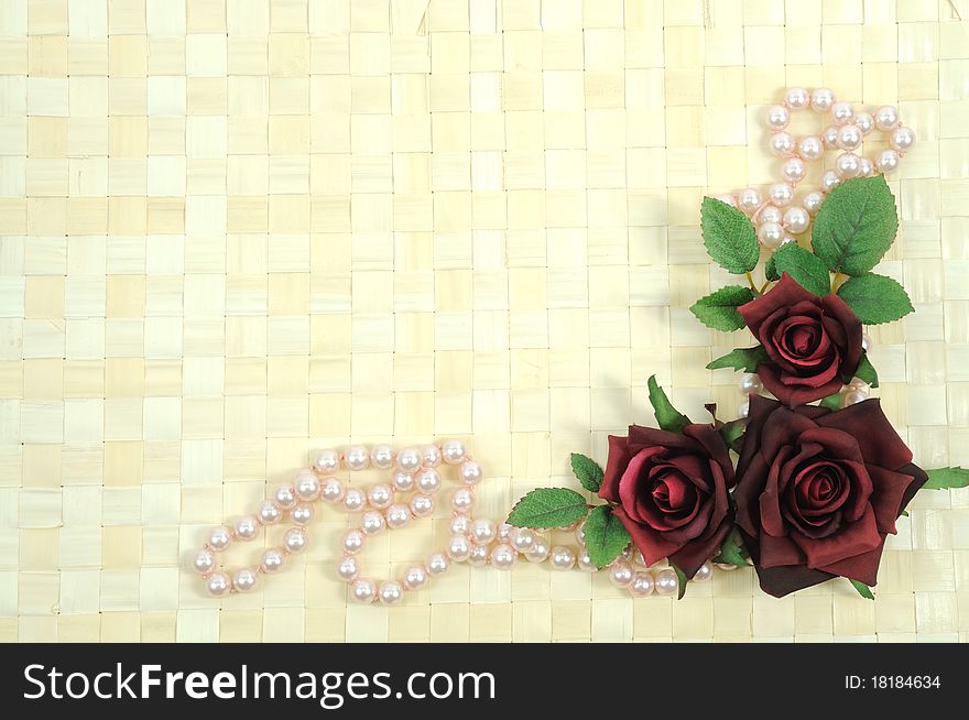 Framework on wooden background from roses and pearls