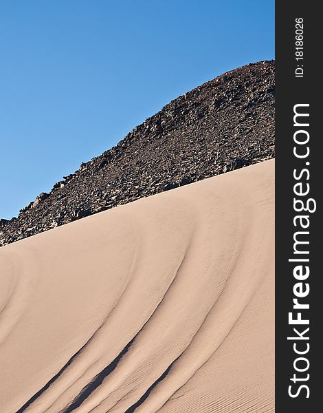 Barkhans of sand among mountains in Arabian desert. Barkhans of sand among mountains in Arabian desert