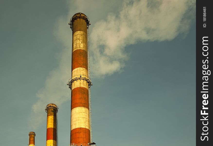 Industrial chimneys against green sky