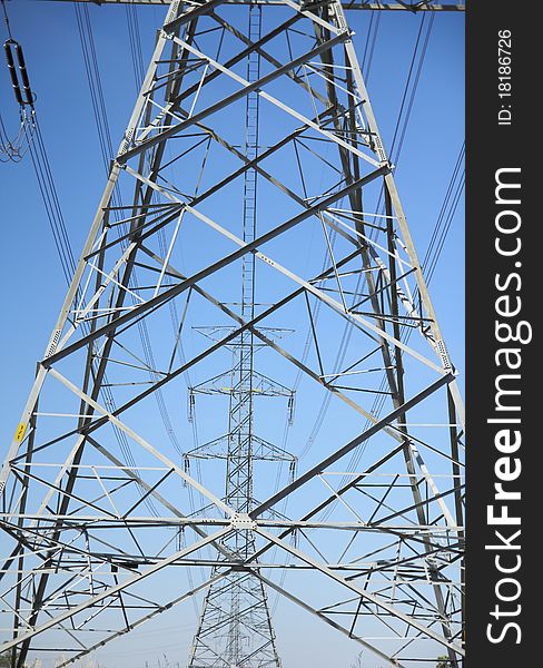 big electricity post with blue sky