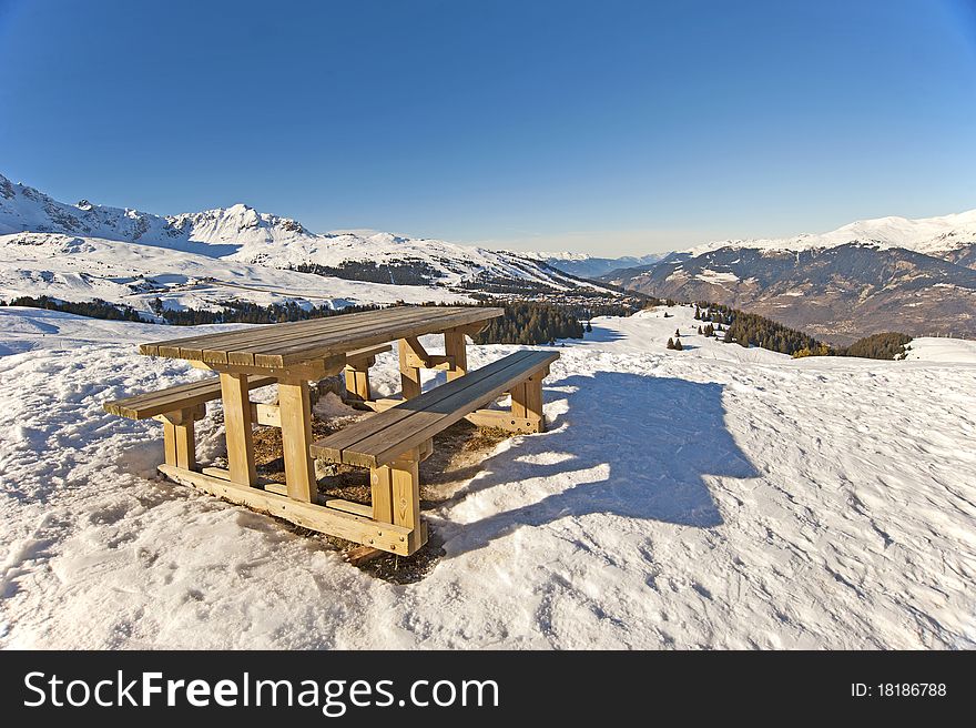 Picnic table on the top of a snowy mountain with a view. Picnic table on the top of a snowy mountain with a view