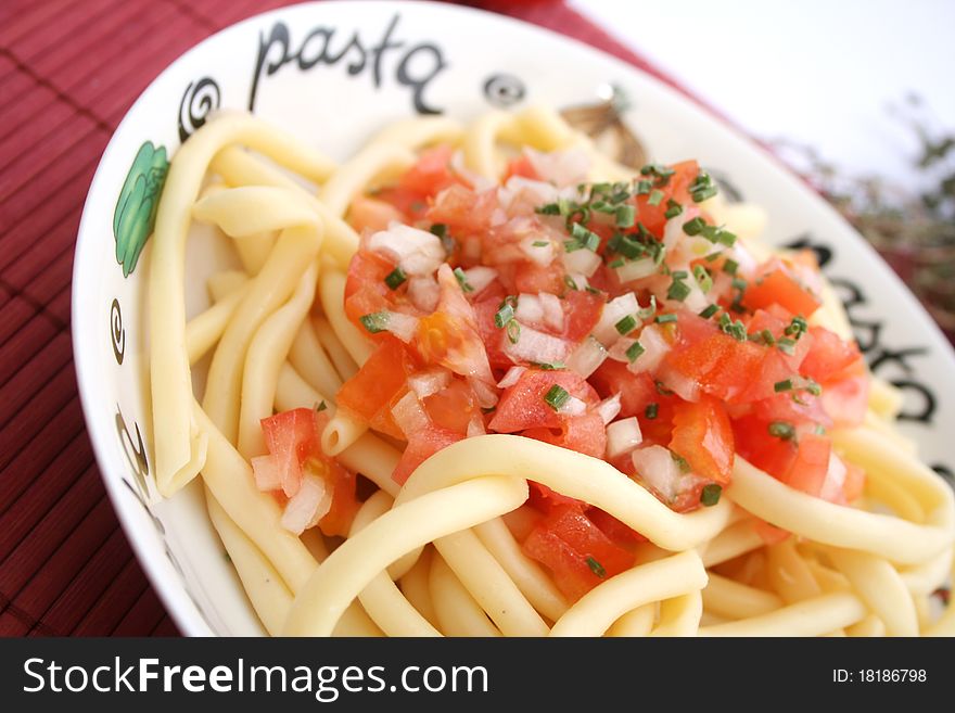 A meal of fresh pasta with tomatoes