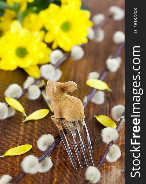 Fork with easter bunny on table with flowers. Fork with easter bunny on table with flowers