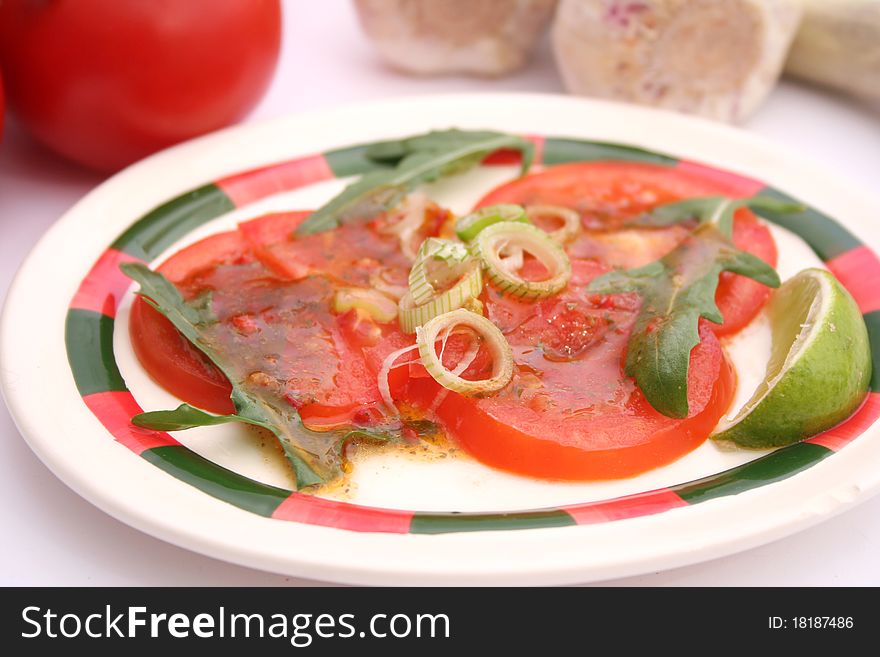 A fresh salad of tomatoes with onions and rucola