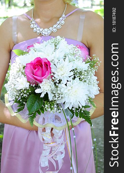 Beautiful white wedding bouquet in hands of the bride.