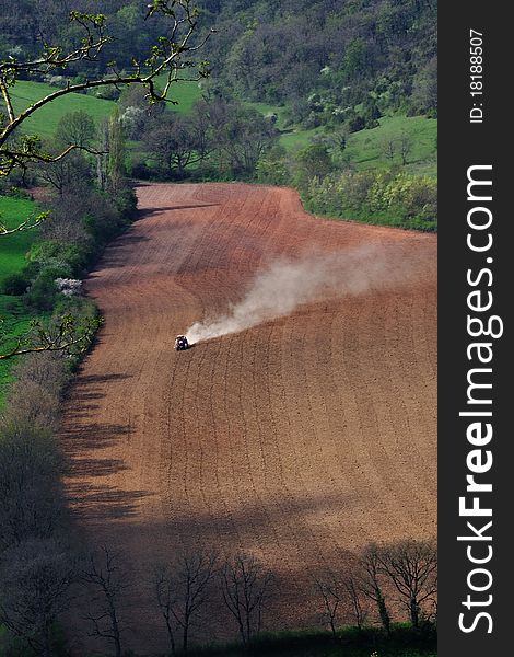 A tractor digs the furrows for the sowing. A tractor digs the furrows for the sowing