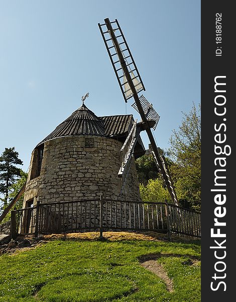 A view of an ancient windmill at the top of an hill. A view of an ancient windmill at the top of an hill