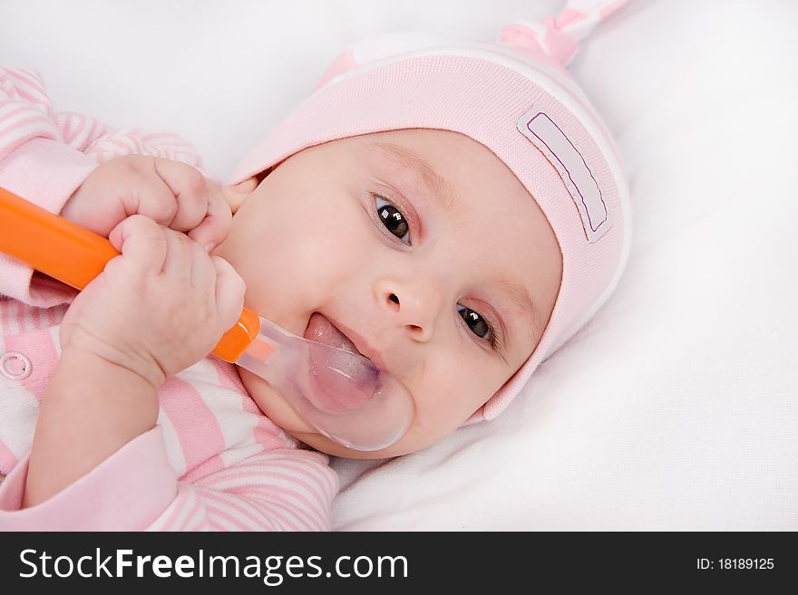 Closeup face of a beautiful newborn girl with spoon