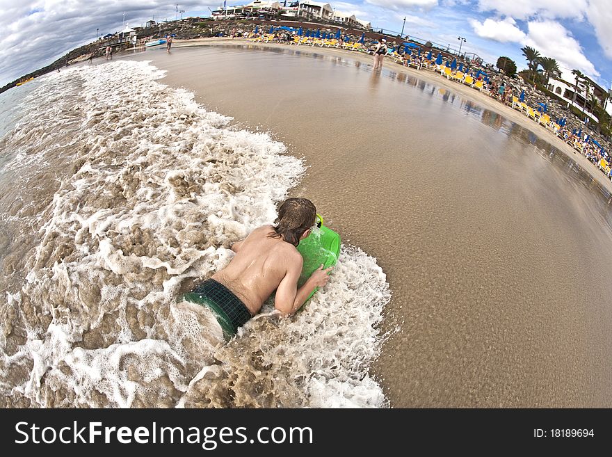 Boy has fun with the surfboard at the beach. Boy has fun with the surfboard at the beach