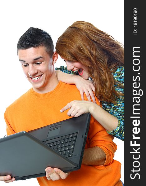 Two smiling teenagers looking at laptop