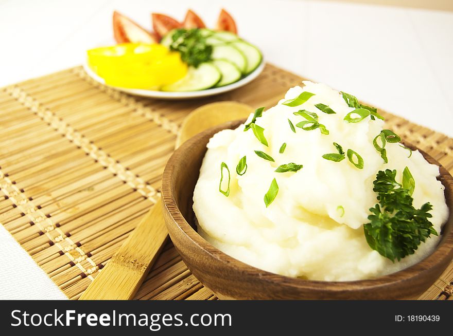 Mashed potatoes with sliced vegetables on a table