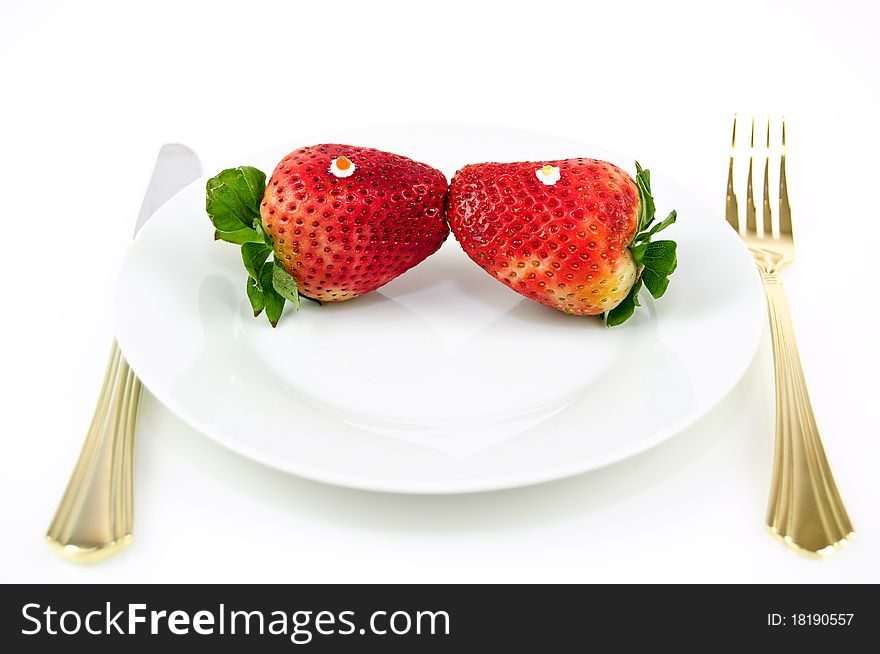 Two strawberry kissing on a plate on a white background. Two strawberry kissing on a plate on a white background