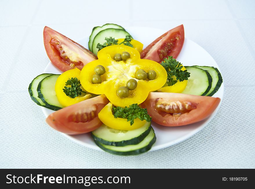 Colored raw vegetables for salad in plate on a table