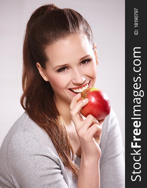 Portrait of cheerful young lady eating an apple isolated over white background. Portrait of cheerful young lady eating an apple isolated over white background