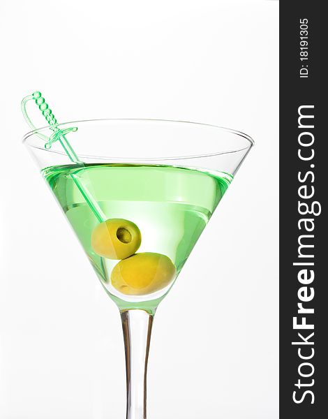 Green alcohol cocktail with dry martini and two olives on skewer. Green alcohol cocktail with dry martini and two olives on skewer