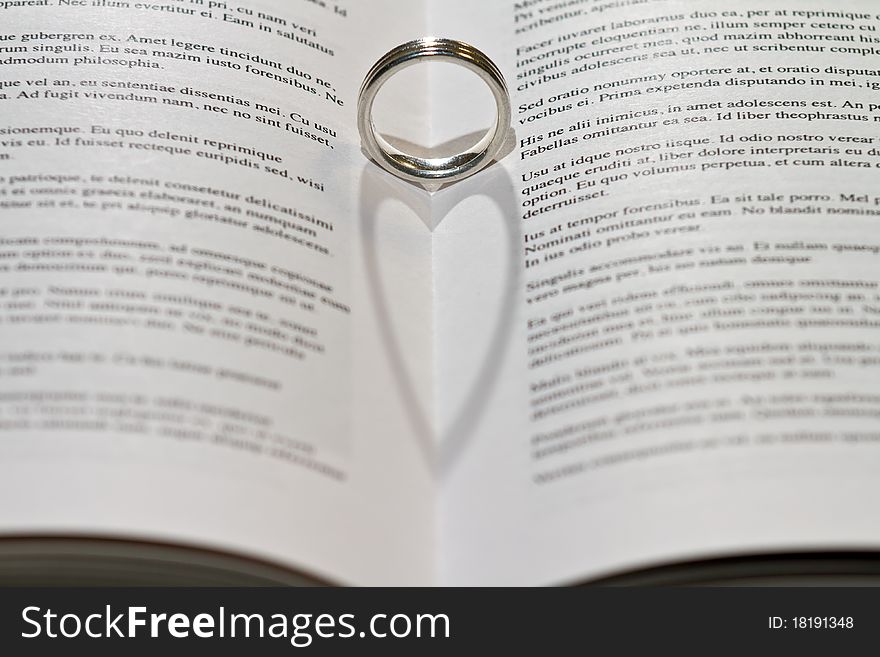 Ring casting heart shadow in book. Ring casting heart shadow in book.