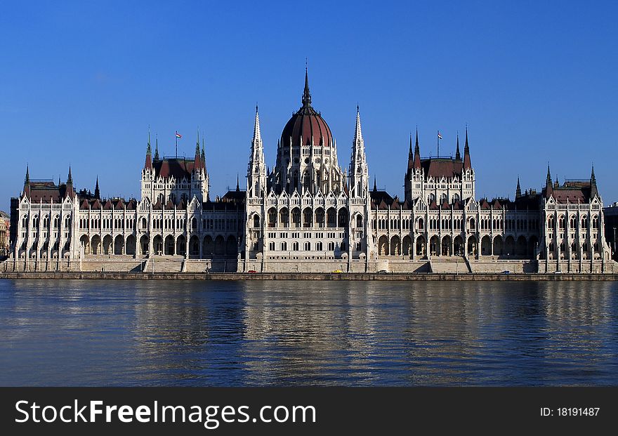 The Hungarian parliament on the bank of Danube Very sunny and bright sky. Reflection on the river. The Hungarian parliament on the bank of Danube Very sunny and bright sky. Reflection on the river.