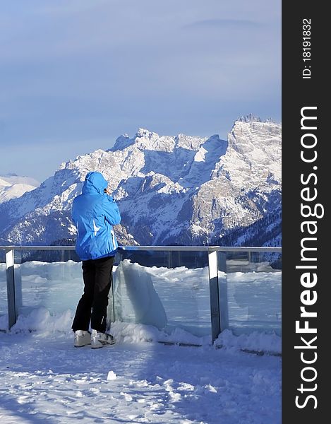 Woman dressed in ski suit admiring the alps from belle view point. Woman dressed in ski suit admiring the alps from belle view point