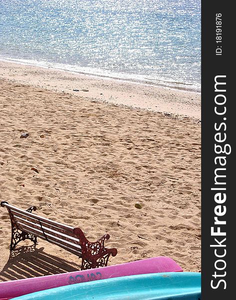 Kayaks and a bench on the beach