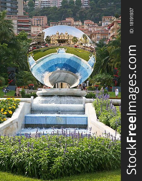 Reflection of Monte Carlo casino in mirror sphere fountain