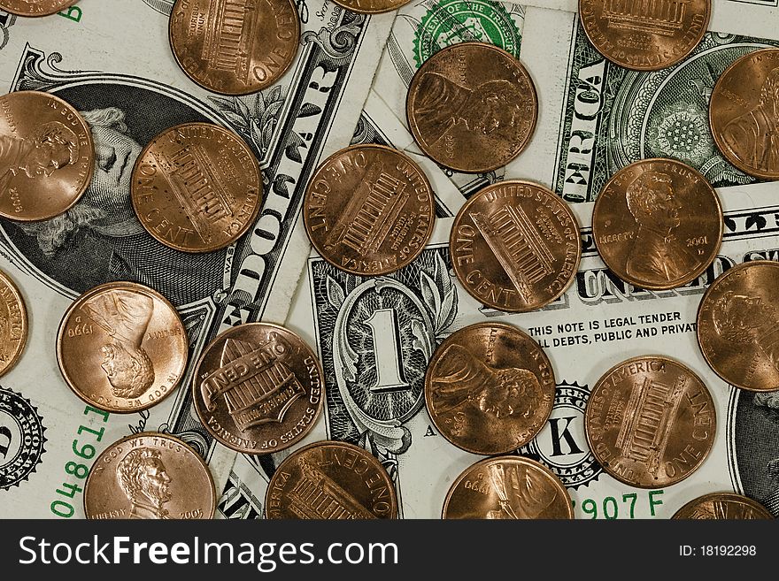 A bunch of pennies covering a bunch of one dollar bills, american currency. A bunch of pennies covering a bunch of one dollar bills, american currency