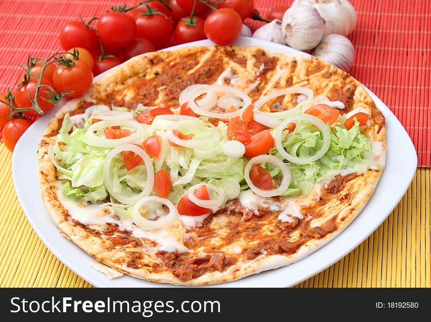 A fresh lahmacun with salad, tomatoes and onions