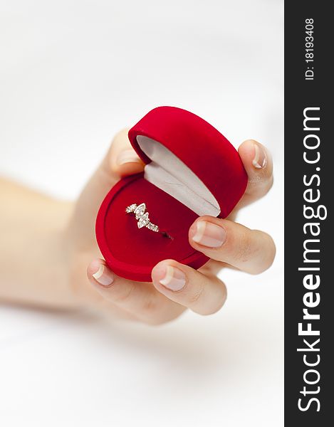 Red box with engagement ring inside held in hand