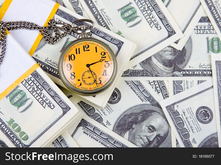 Pocket watch on a stack of dollars