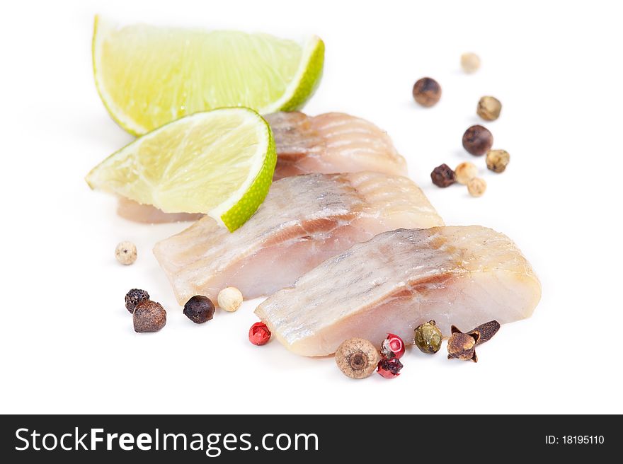 Isolated pieces of salt herring fish with lime