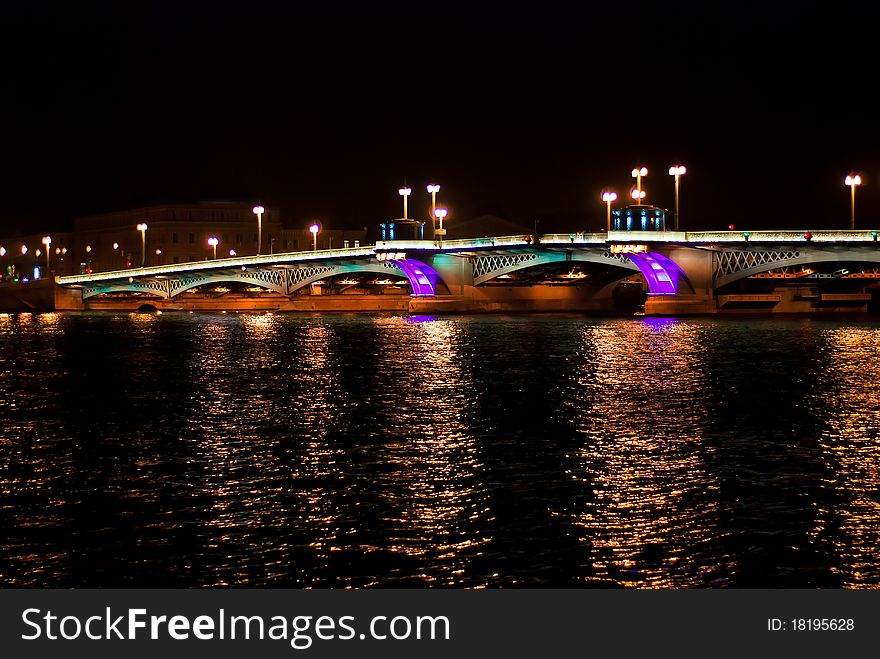 Night bridge in St. Petersburg city with violet illumination