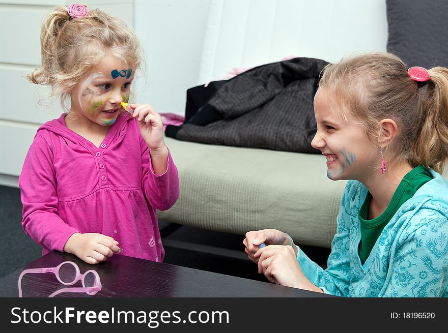 Little girls making face painting. Little girls making face painting