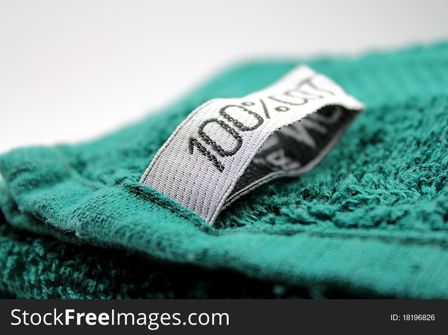 100% cotton label on green towel. 100% cotton label on green towel