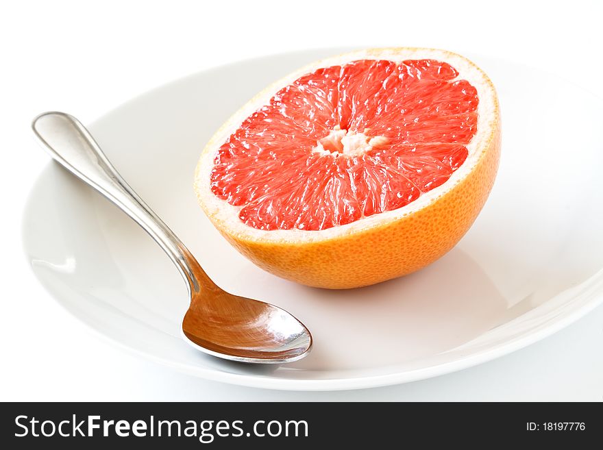 Fresh grapefruit with plate and spoon,