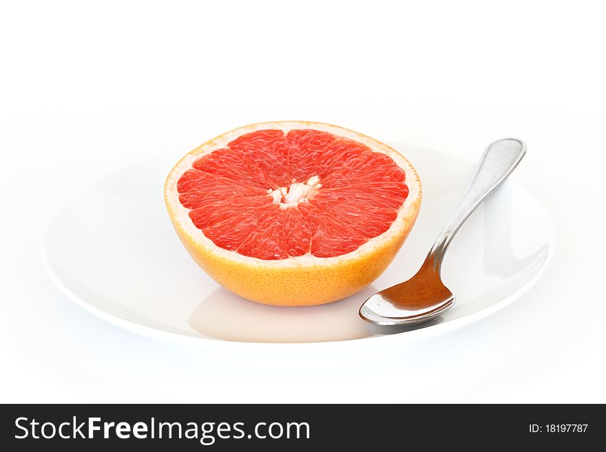 Half grapefruit with plate and spoon, picture from top. Half grapefruit with plate and spoon, picture from top