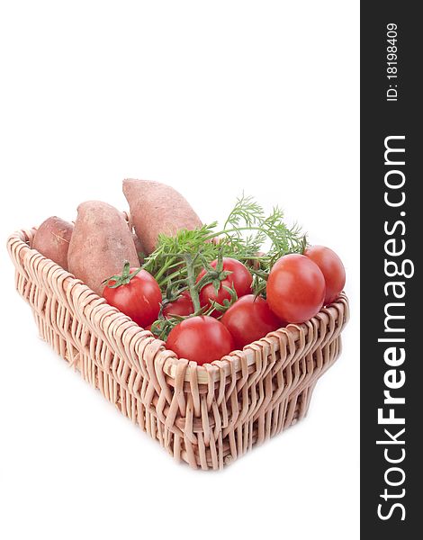 Wooden basket of fresh raw potatos tomatos and carrot. Wooden basket of fresh raw potatos tomatos and carrot