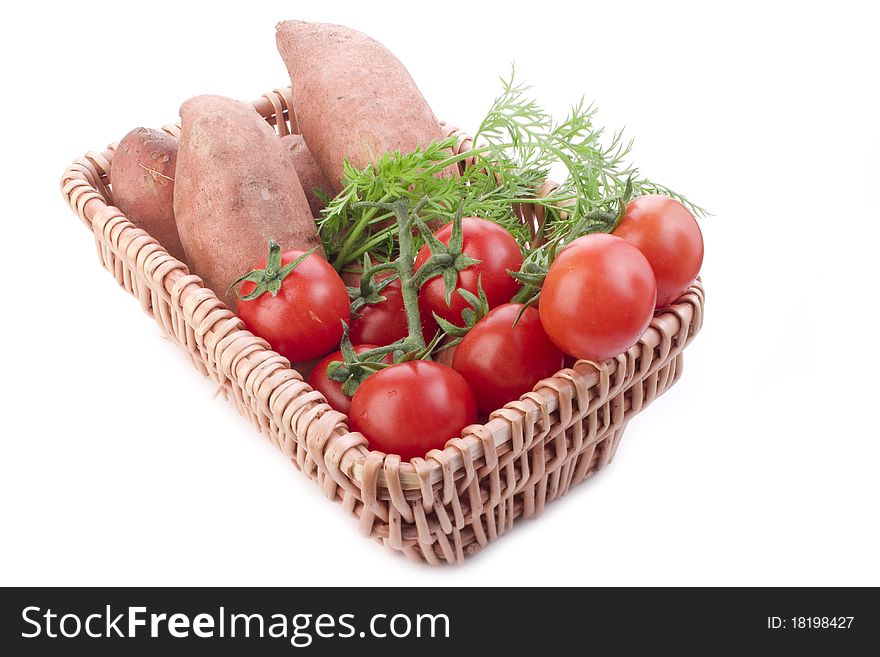 Wooden basket of fresh rwa potatos tomatos and carrot. Wooden basket of fresh rwa potatos tomatos and carrot