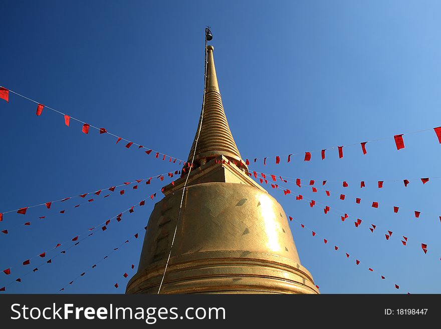 Golden pagoda with red flag of buddhism spell at wat sreket, bangkok, thailand