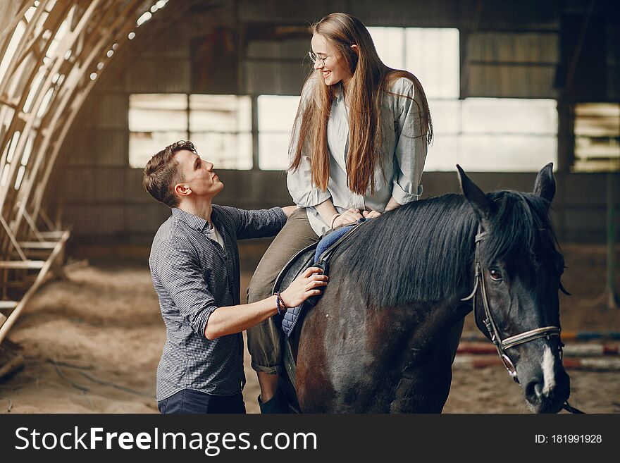 Couple on a ranch. Pair standing with a horse. Girl with her boyfriend. Couple on a ranch. Pair standing with a horse. Girl with her boyfriend