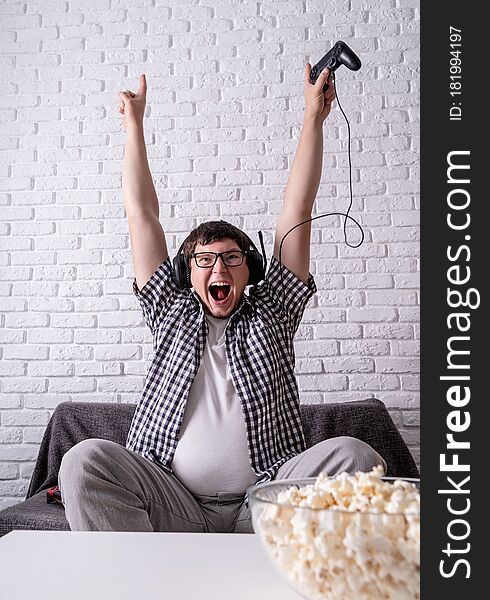 Excited Young Man Playing Video Games At Home Enjoying His Victory