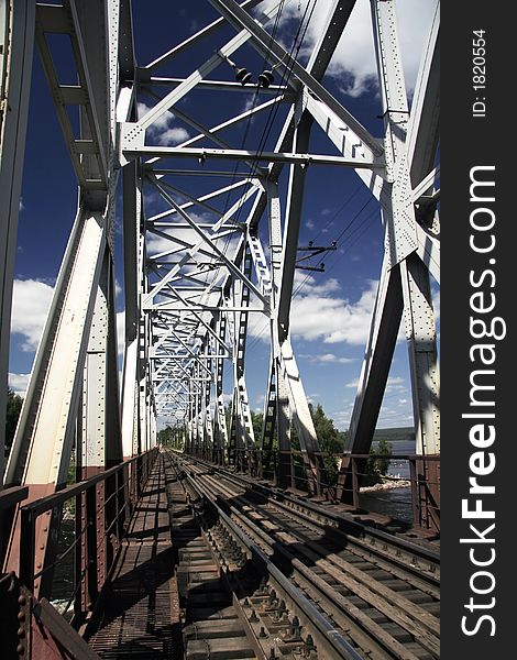 Railway bridge at noon under cloudy sky