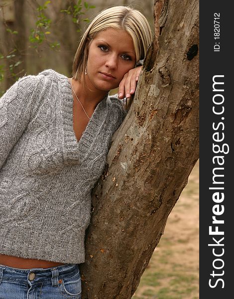 Young beautiful woman wearing a grey sweater outside. Young beautiful woman wearing a grey sweater outside