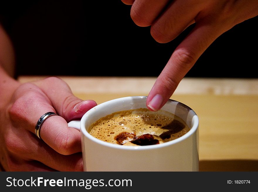 Stirring coffee with fingers at a cafe