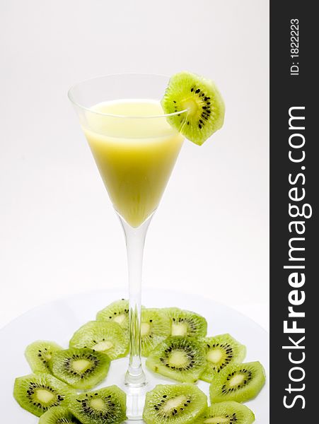 Healthy glass of juice with green kiwi slices around over white background. Healthy glass of juice with green kiwi slices around over white background