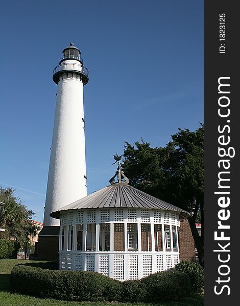 White gazebo and lighthouse against blue sky