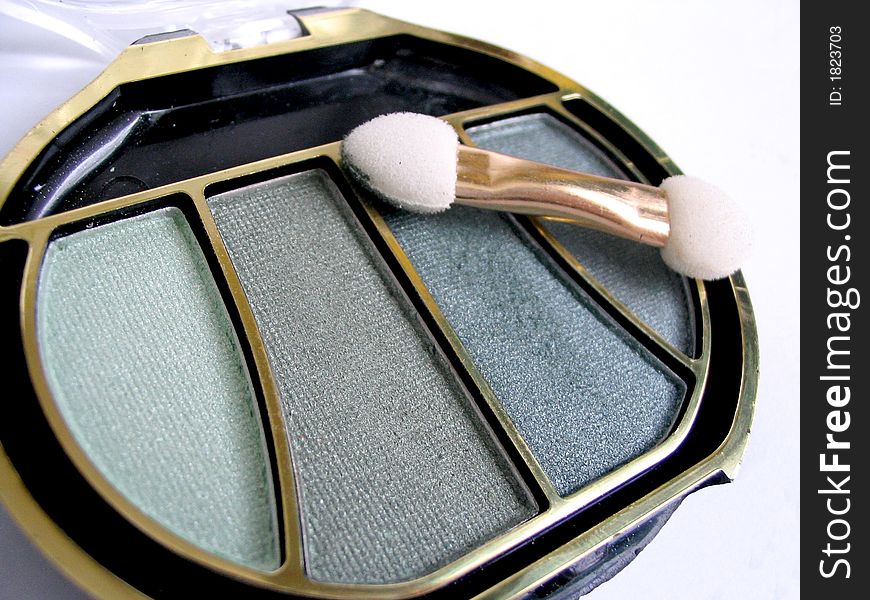Green eyeshadow and brush macro closeup