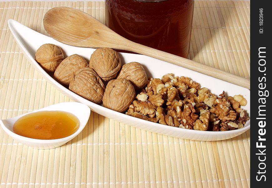 Some nuts with sweet honey and wooden spoon