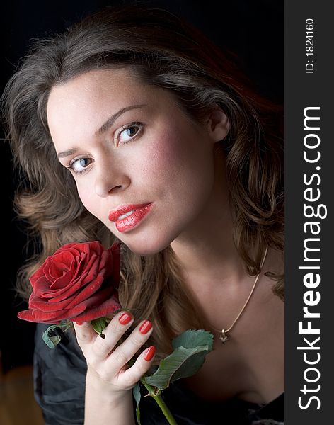 Lady with red rose portrait against black background. Lady with red rose portrait against black background.