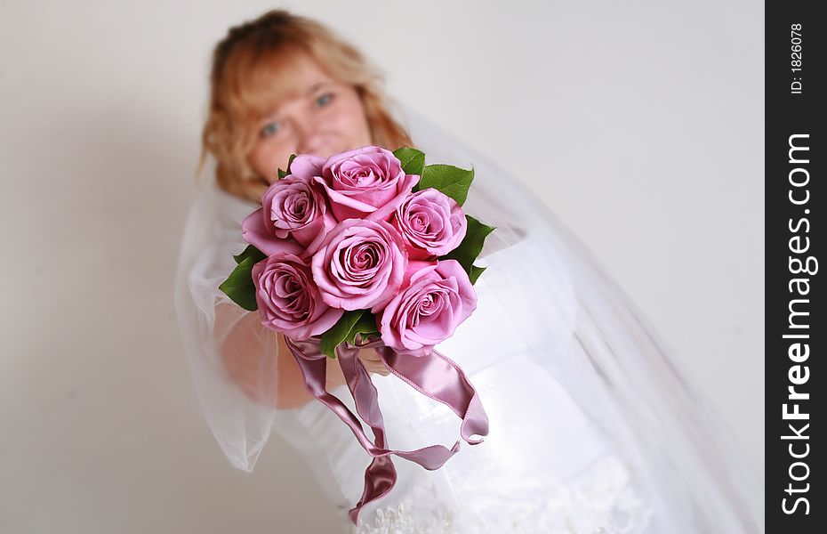 Beautiful bride and her bouquet of pink roses. Beautiful bride and her bouquet of pink roses.