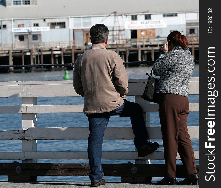 Couple on a railing at a pier