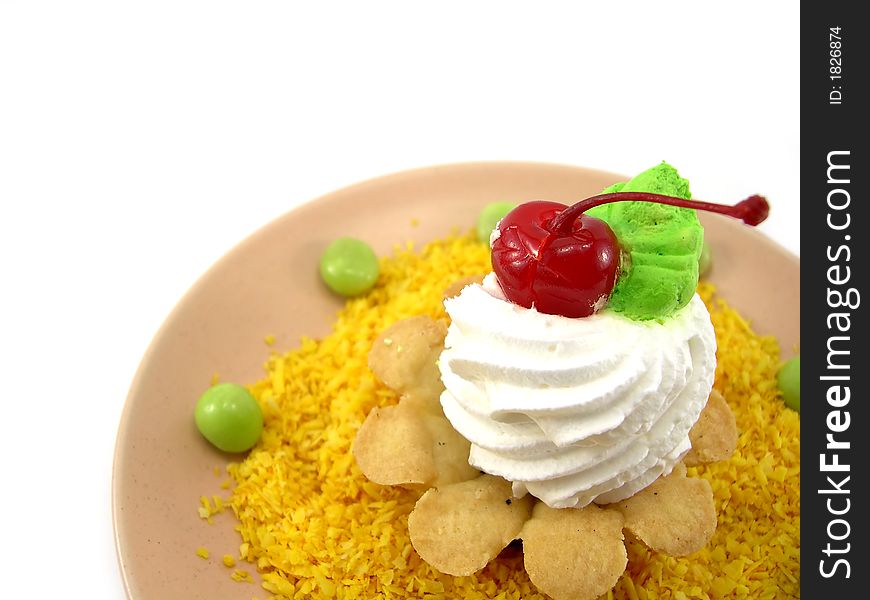 Beautiful cake as a basket with a cherry on a plate in a yellow coconut shaving on a white background